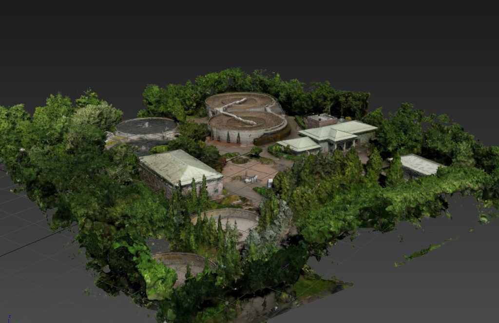 Export brut d'un scan par drone : le nuage de points texturé d'une station de traitement de l'eau, bassins circulaires et bâtiments entourés d'arbres.